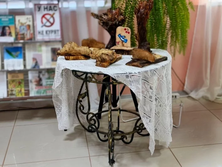 Кованный стол и деревянные изделия мастера стоят в библиотеке Тугулыма.