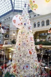 Самая высокая ёлка универмага притягивает гостей сиянием огней.