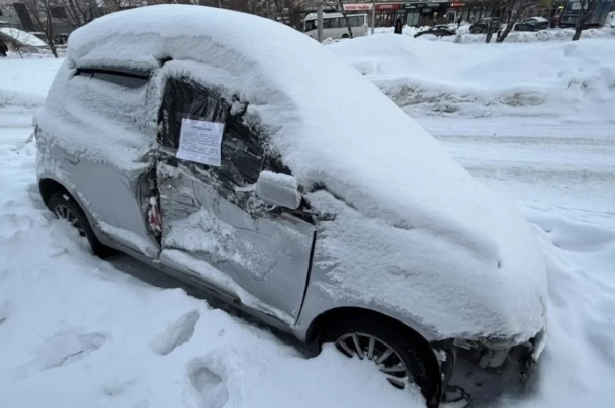 Эвакуация брошенной Тойоты Витц в Дзержинском районе Новосибирска Бесхозный автомобиль Toyota Vitz, покрытый снегом, на улице Кошурникова в Новосибирске