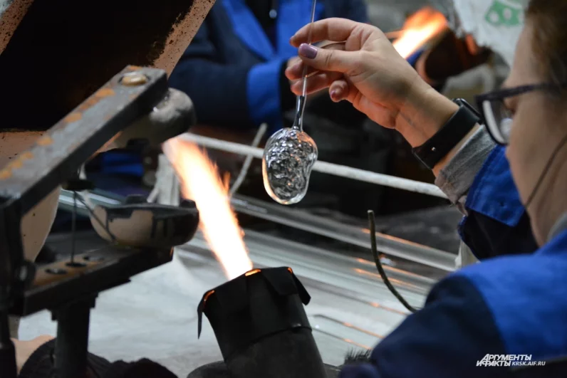 Одна из мастериц формует новую игрушку — стеклянный бутерброд с икрой. Это украшение уже стало одним из самых популярных в фирменном магазине.