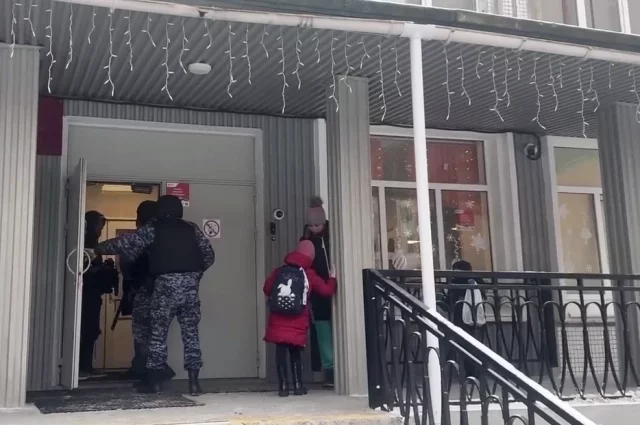 Сотрудники Росгвардии заходят в учебное заведение.