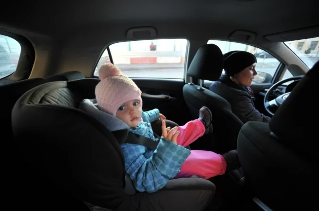 Ребенок в детском автомобильном кресле.