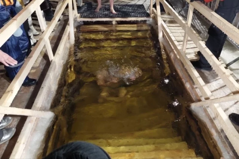 Троекратное погружение в воду с молитвой и крестным знамением.