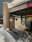 Снег продавил стеклянные панели на остановке. 