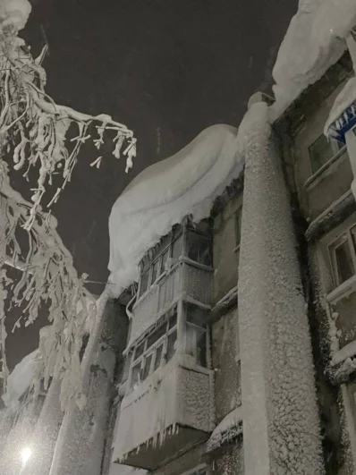 Опасные снежные шапки свисают с крыш. 