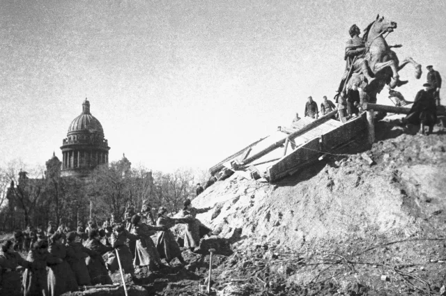 После снятия блокады Ленинграда жители города освобождают памятник Петру I от защитных укрытий.
