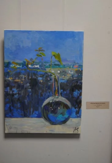 Немножко меланхоличная картина, на которой виден росток в бутылке на зимнем окне.