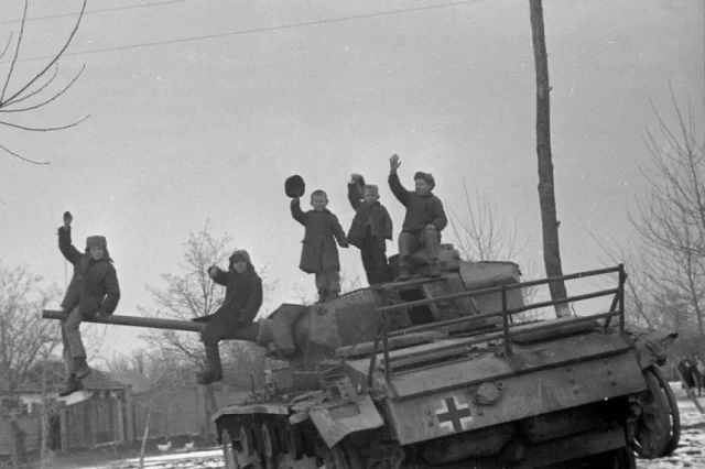 Гулькевичские ребята зимой 1943 года приветствуют красноармейцев с подбитого немецкого танка.