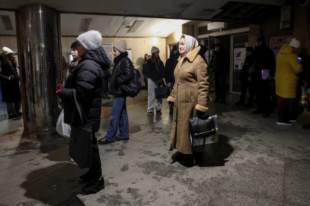 Люди стоят у входа на станцию метро, поскольку киевский метрополитен вынужденно прекратил работу.