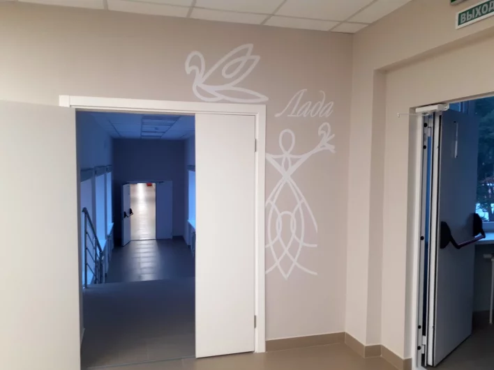 Эмблема гимназии - древнерусская богиня-берегиня Лада: женщина в широкой юбке колоколом  с поднятыми руками, переходящими в птиц .