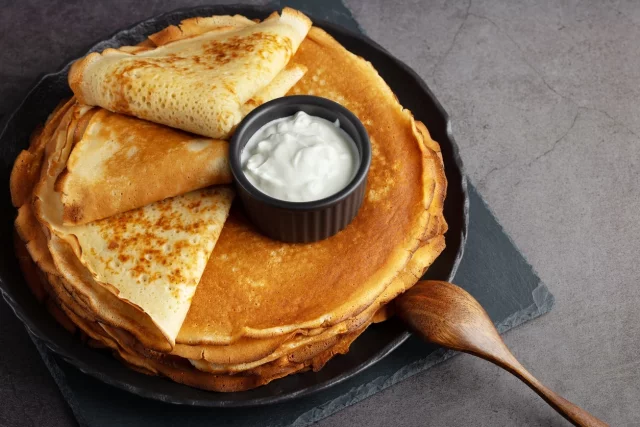 На Масленицу многие едят блины со сметаной.