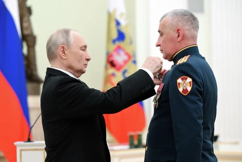 Президент РФ Владимир Путин и командир 901 полка оперативного назначения 116 отдельной бригады особого назначения Южного округа войск национальной гвардии Российской Федерации полковник Александр Рукосуев, награжденный орденом Мужества.
