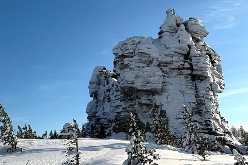 Скалы-останцы среди снега возвышаются на десятки метров.