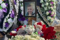 На деревянном кресте висит фотография Вани — улыбчивого, красивого и совсем юного. 