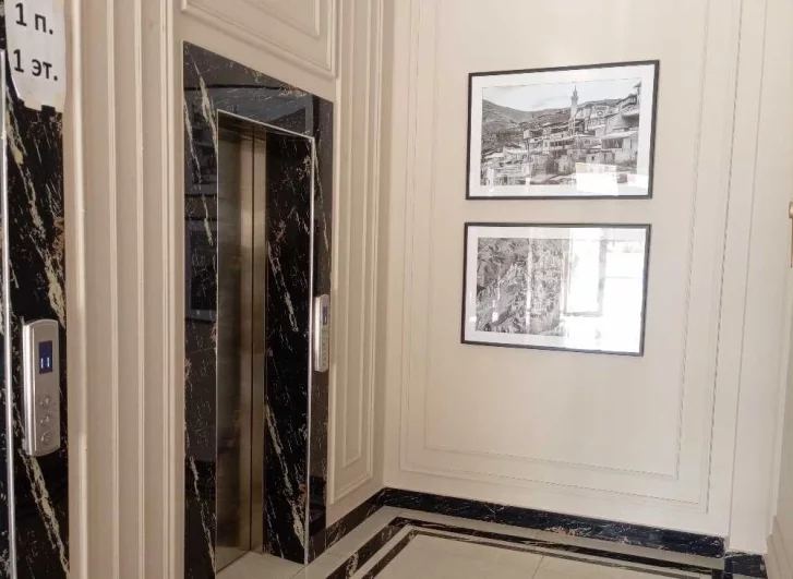 Лифты - грузовой и пассажирский - облицованы чёрным мрамором.