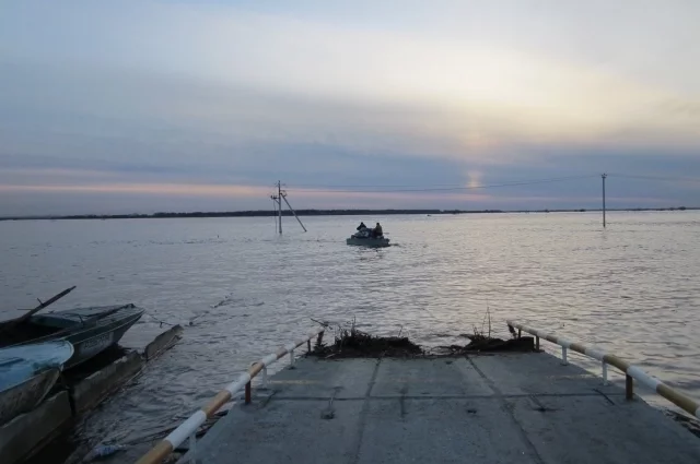 Трудно поверить, что по этой дороге совсем недавно ездили машины. Теперь асфальт уходит куда-то в подводное царство, а добраться до «большой земли» можно только на водном транспорте.