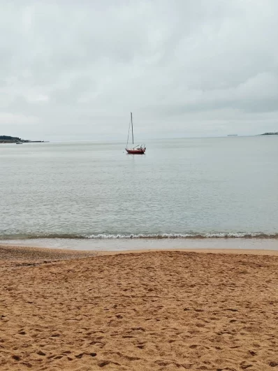 Одинокая яхта вдали как арт-объект на фоне безмятежного моря. 