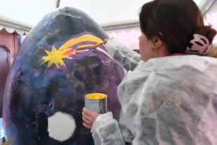 Где звёзды, там и вера. На снимке: участница арт-фестиваля «МедиаПасха» в Москве расписывает «космическое» пасхальное яйцо.