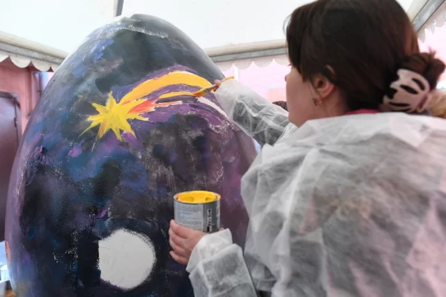 Где звёзды, там и вера. На снимке: участница арт-фестиваля «МедиаПасха» в Москве расписывает «космическое» пасхальное яйцо.