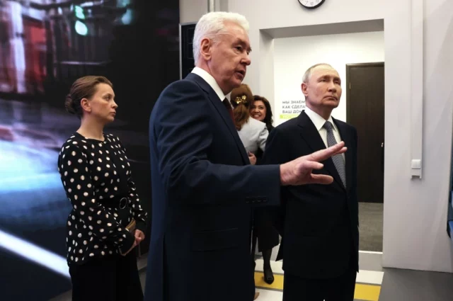 Президент Владимир Путин и мэр Москвы Сергей Собянин (в центре) во время посещения Единого центра поддержки участников СВО и членов их семей