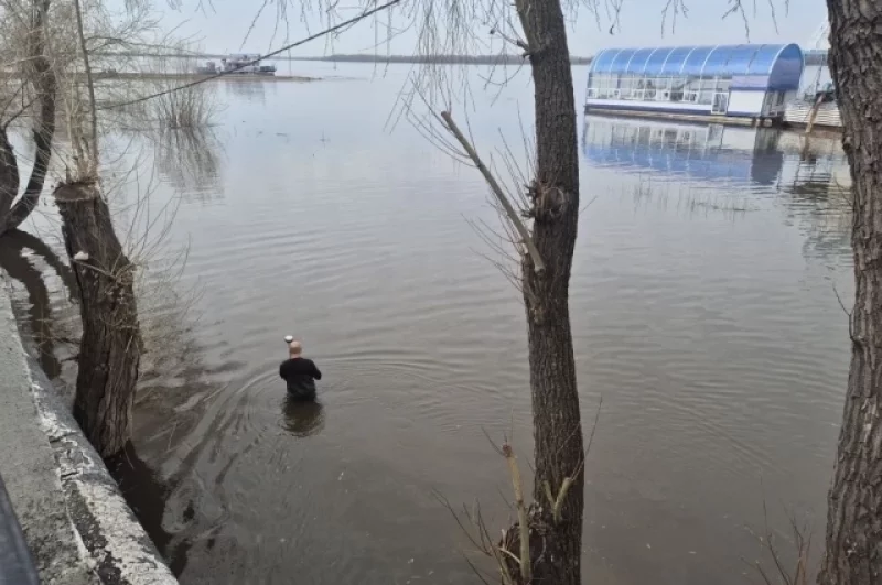 Специалист в гидрокостюме производит замер уровня воды.