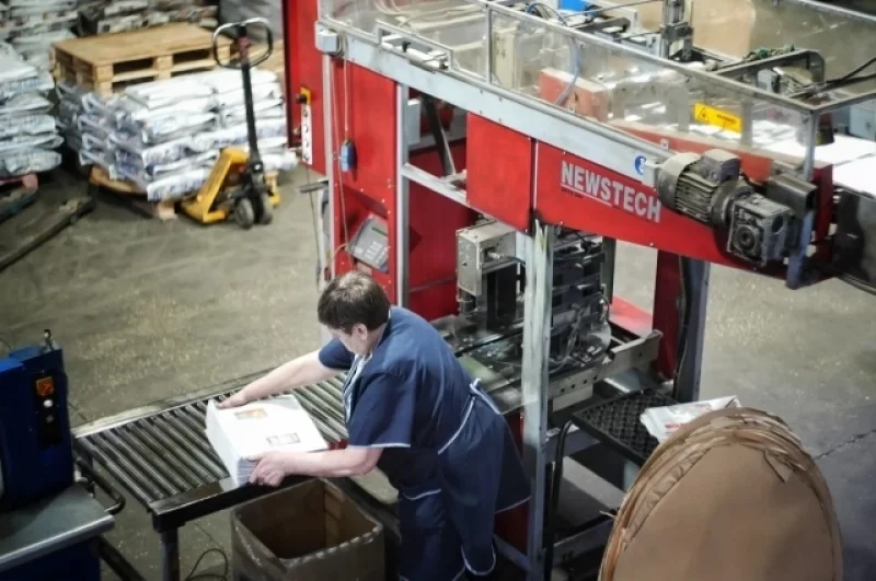 Упаковщица проверяет качество сгиба и счёт листов, формируя аккуратные пачки для отправки.