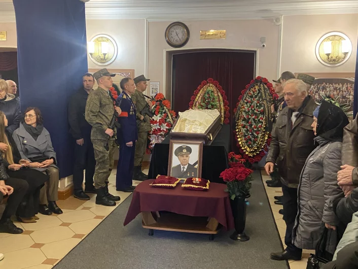 Люди несут живые цветы.