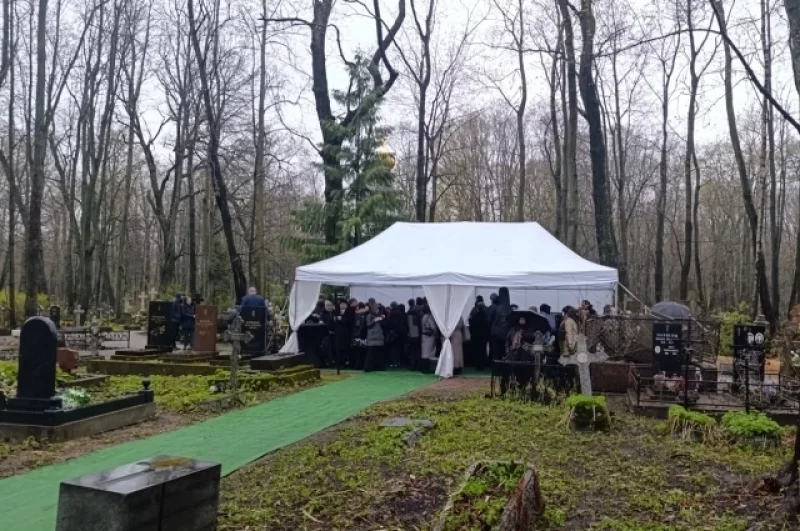 Несмотря на погоду, людей на кладбище приехало много.