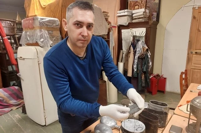 Хранитель коллекции Александр Королёв показывает шейный жетон узника фашистского концлагеря.