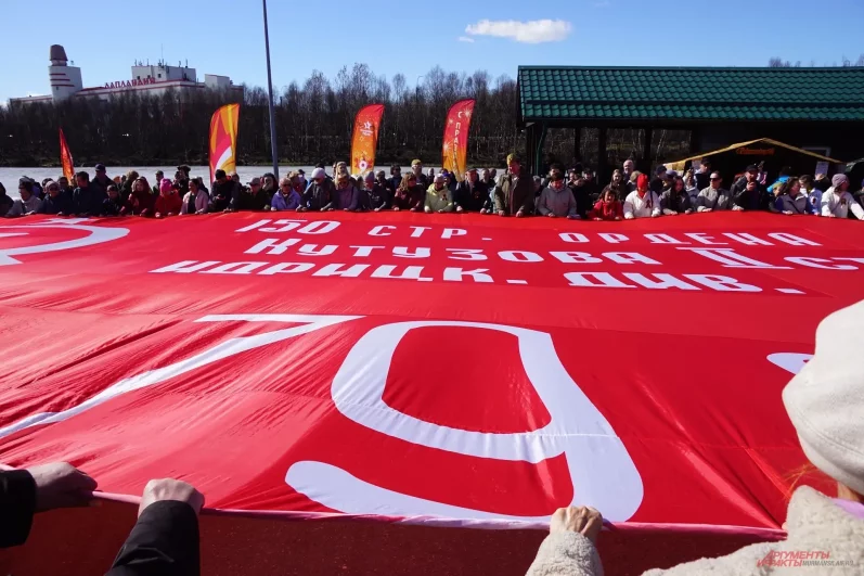 Жители и гости города развернули полотнище точной копии Знамени Победы. 