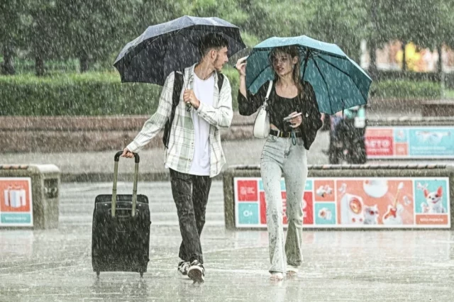 Прохожие во время сильного дождя в Москве.