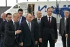 24 июня 2026. Президент РФ Владимир Путин осматривает образцы новых российских самолетов в ангаре Лётно-исследовательского института имени М. М. Громова в Жуковском. Слева направо: генеральный директор государственной корпорации «Ростех» Сергей Чемезов, руководитель Федерального агентства воздушного транспорта (Росавиации) Дмитрий Ядров, генеральный директор Объединённой авиастроительной корпорации (ОАК) Вадим Бадеха, министр промышленности и торговли РФ Антон Алиханов, министр финансов РФ Антон Силуанов, первый заместитель председателя правительства РФ Денис Мантуров, пресс-секретарь президен