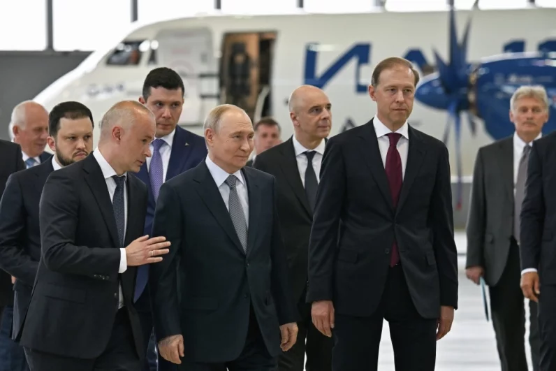 24 июня 2026. Президент РФ Владимир Путин осматривает образцы новых российских самолетов в ангаре Лётно-исследовательского института имени М. М. Громова в Жуковском. Слева направо: генеральный директор государственной корпорации «Ростех» Сергей Чемезов, руководитель Федерального агентства воздушного транспорта (Росавиации) Дмитрий Ядров, генеральный директор Объединённой авиастроительной корпорации (ОАК) Вадим Бадеха, министр промышленности и торговли РФ Антон Алиханов, министр финансов РФ Антон Силуанов, первый заместитель председателя правительства РФ Денис Мантуров, пресс-секретарь президен