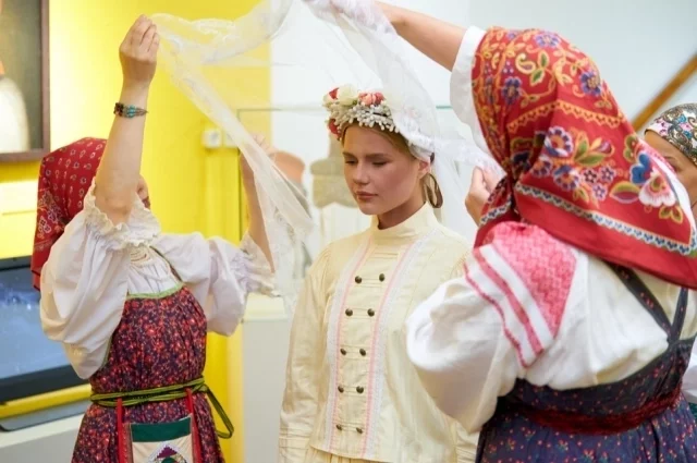 Традиционно перед церемонией мама заплетала невесте  косу, а помощницы облачали в свадебный наряд.