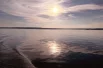 Солнце медленно опускается к горизонту, вода становится темнее, а небо окрашивается в нежные розовые и золотистые оттенки.