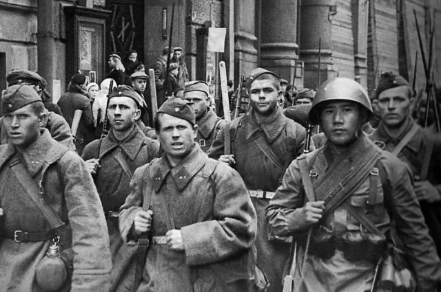 Советская пехота проходит по ленинградским улицам, направляясь на фронт.