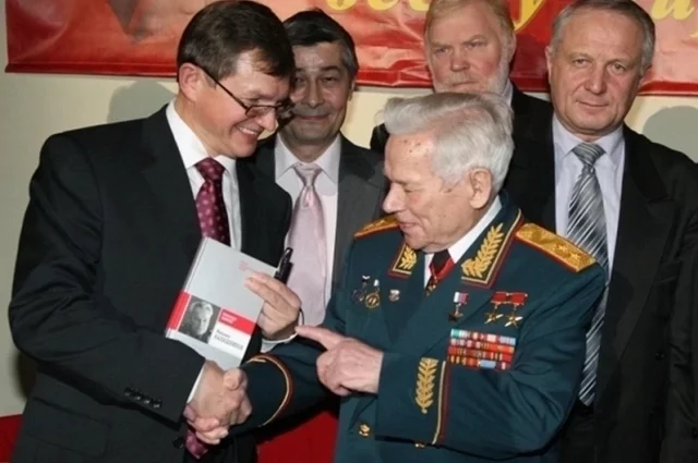 Александр Ужанов вручает книгу-биографию Михаилу Калашникову