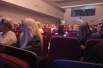 Публика занимает места в зрительном зале.