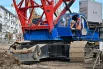 Машинисты тяжелых гусеничных кранов контролируют рабочий процесс на одном из самых сложных участков возведения новой радиальной линии метро.